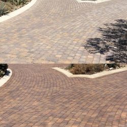 Two images showing a paved brick driveway with slight curves and landscaped edges featuring desert plants.